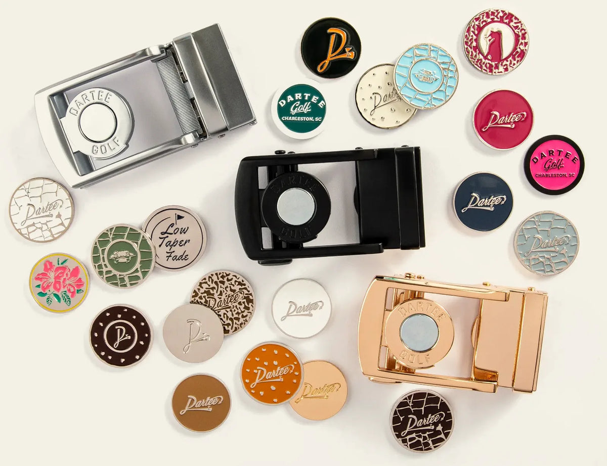 Three Dartee magnetic buckles surrounded by colorful ball markers on a cream background
