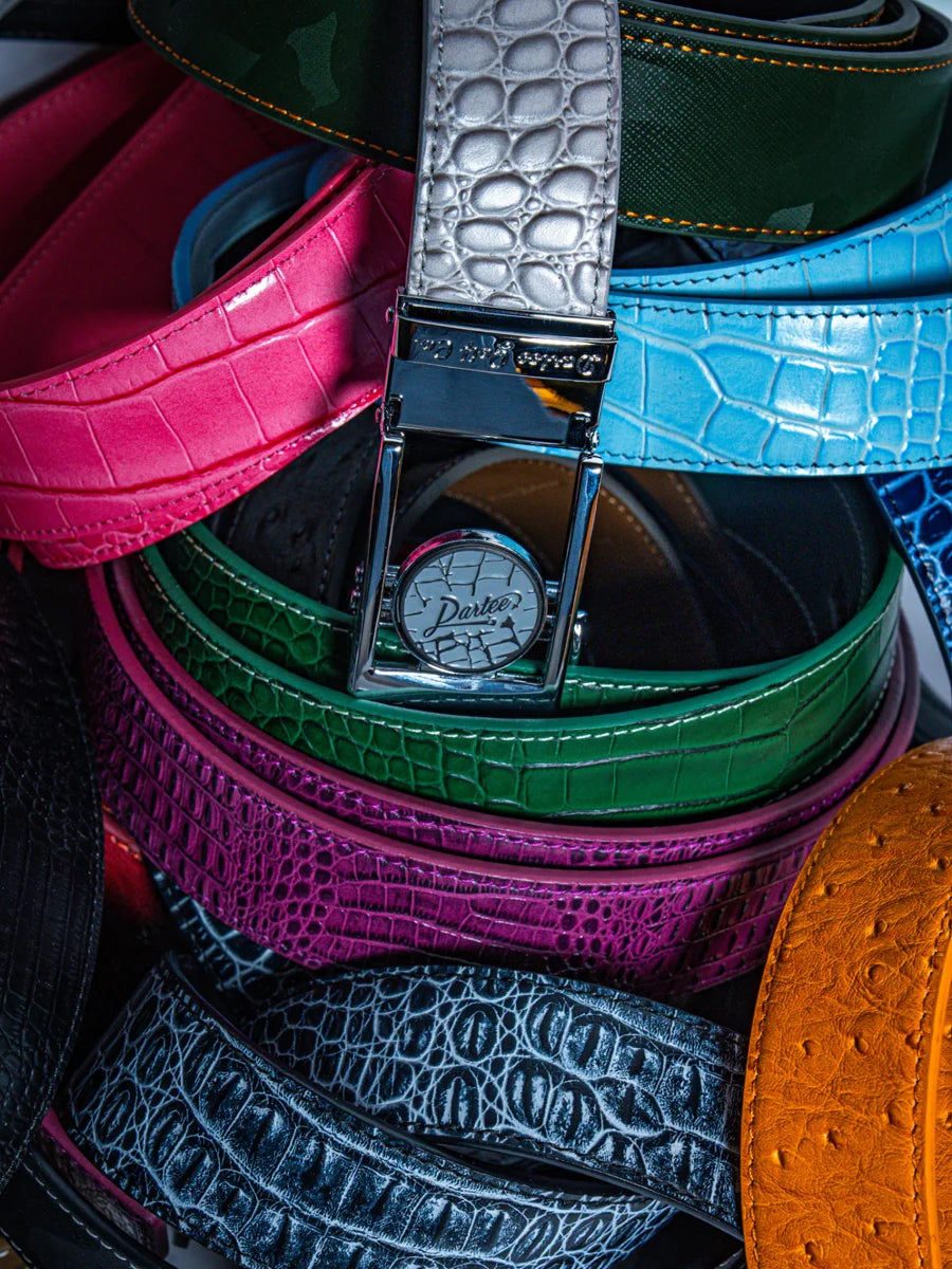 Colorful textured Dartee golf belts surrounding a silver magnetic buckle