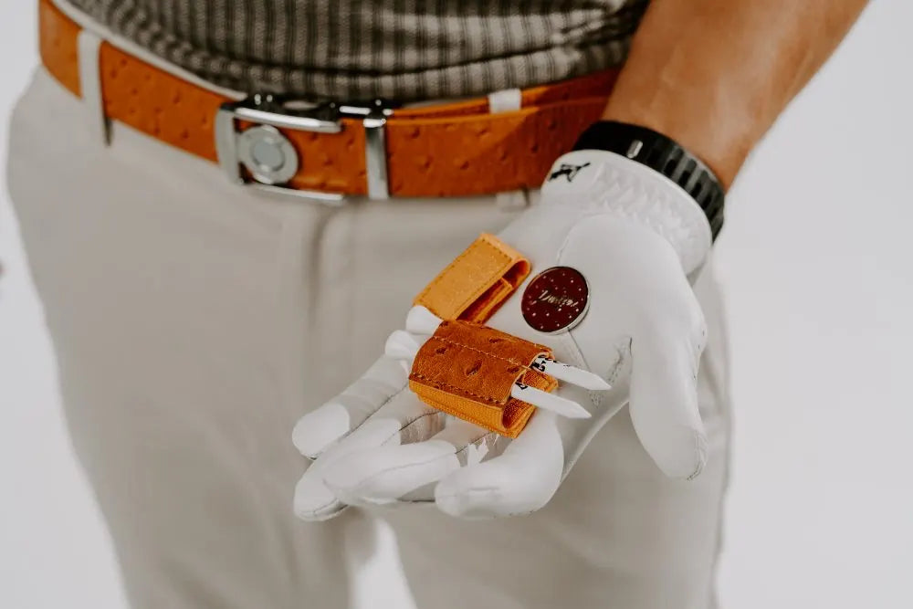 Dartee tee and glove holders detached and held in a golfer’s hand
