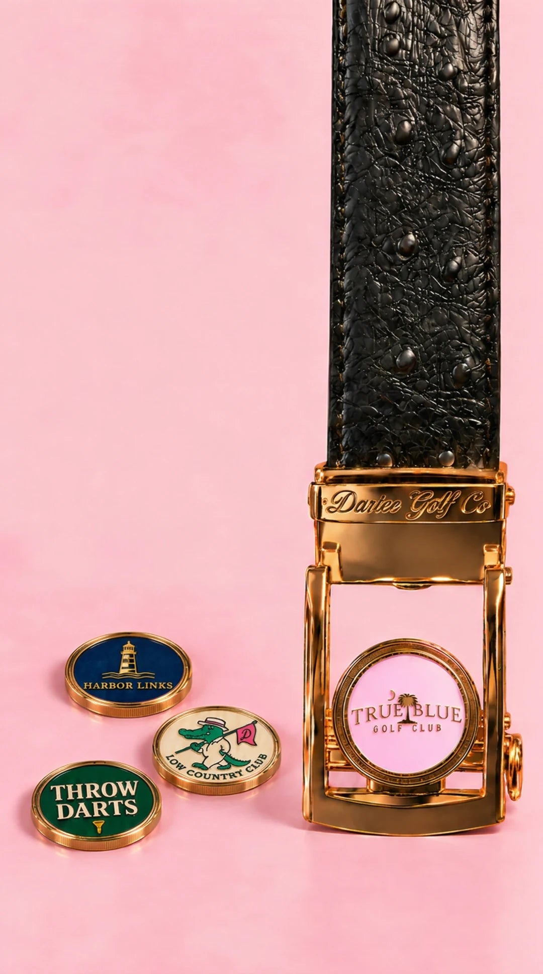 Black Dartee belt with a gold buckle and magnetic ball markers on a pink studio background